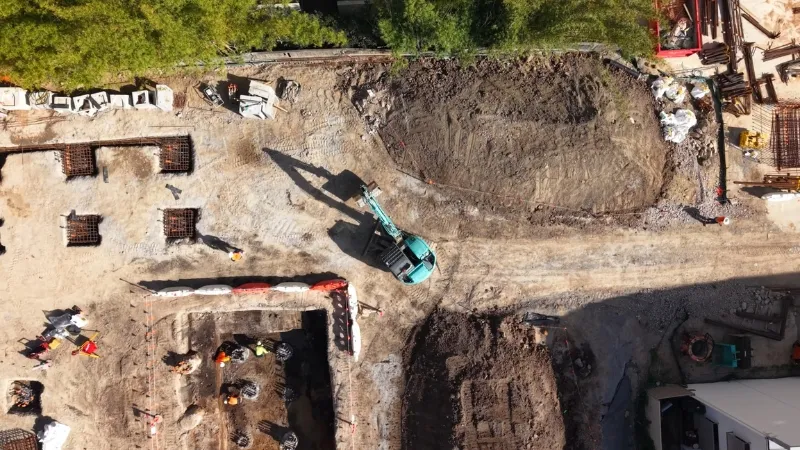 Aerial view of construction site with excavation, earthworks, and machinery operations